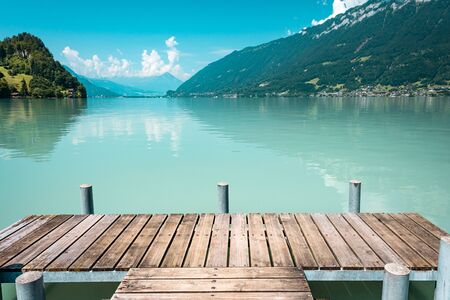Majestic lake with clear turquoise water. Wooden pier. Brienz lake in the village of Iseltwald, Switzerlandの写真素材