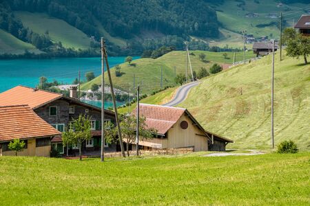 View of swiss village Lungern with traditional houses along the lake Lungerersee, canton of Obwalden, Switzerland. Incredibly bewitching and calm place.の写真素材