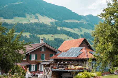 Beautiful traditional wooden house in the alpine village, Switzerland. House decorated with flowers,...