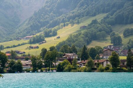 View over the lake at with mountains in the background. Houses on the shore of a picturesque lake.の写真素材