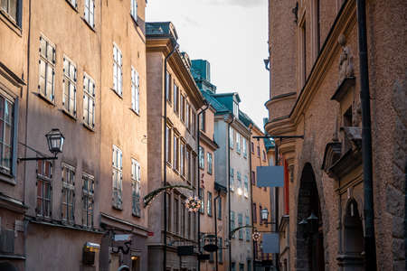 Narrow streets with New Years, Christmas decorations, festive garlands and stars on the facades of...
