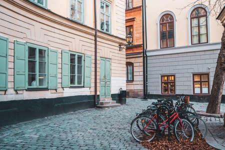 Bicycles on an empty Scandinavian cobblestone street, a cozy courtyard with historic buildings, old facades with shuttered windows, Stockholm, Swedenの写真素材