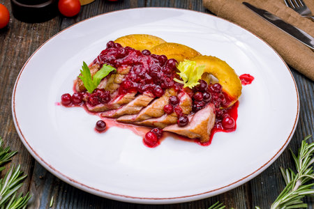 Duck breast with berry sauce on white plateの写真素材