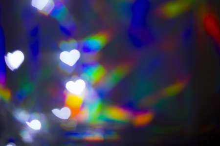 Blurred white heart shape bokeh on rainbow light backgroundの写真素材