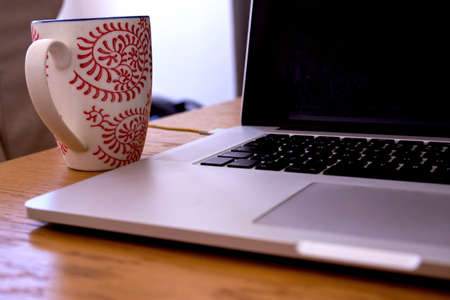 Laptop and coffee mug. Working from home and remote access concept. wort at home with coffee and...