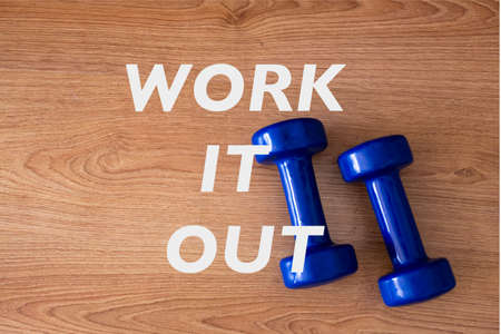 fitness weights dumbbells for exercise concept. Exercise and fitness equipment at home for basic work out with blue dumbbells and wooden backgroundの写真素材