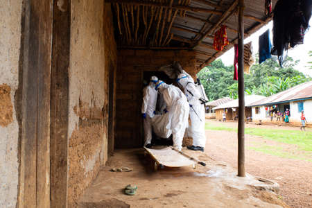 Lunsar, Sierra Leone, June 24, 2015: the burial team takes a dead person from the interior of a house. ebola response epidemic disease in Africa, ebola and corona virus contextのeditorial素材