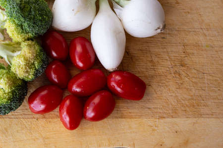 fresh vegetables, chives, broccoli and cherry tomatoes with wooden background, top view, copy spaceの写真素材