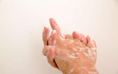 Closeup of person washing hands isolated in white background. Cleanliness and virus protection concept.の写真素材