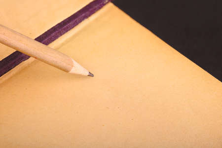 simple wooden pencil and notepad on black backgroundの写真素材