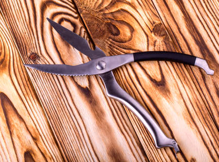 metal shiny kitchen scissors on a wooden tableの写真素材