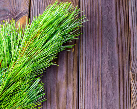 green branches of a Christmas tree on a wooden backgroundの写真素材
