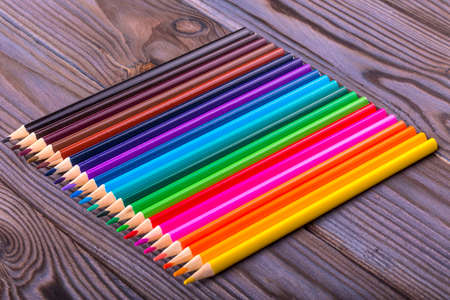 Colour pencils on black wooden background close upの写真素材