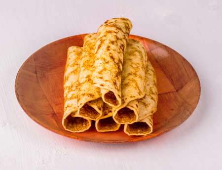 freshly baked pancake baked in red plate on the white tableの写真素材