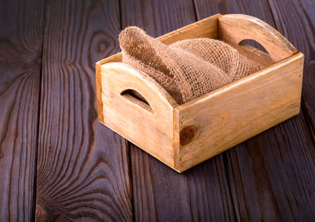 Wooden box on sack cloth on wooden backgroundの写真素材