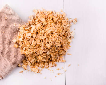 seasoning mixture roots poured into the burlap and a white wooden tableの写真素材