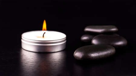spa composition. black stones and a candle on black  backgroundの写真素材