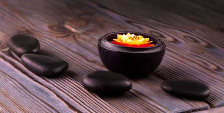 spa composition. black stones and a candle on white backgroundの写真素材