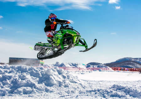 snowmobile rider jumping through snowのeditorial素材