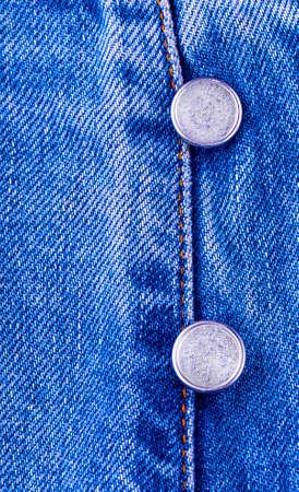 Metal buttons on blue jeansの写真素材