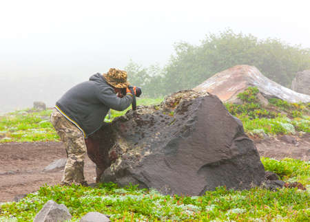 photographer in the fog takes a picture of nature