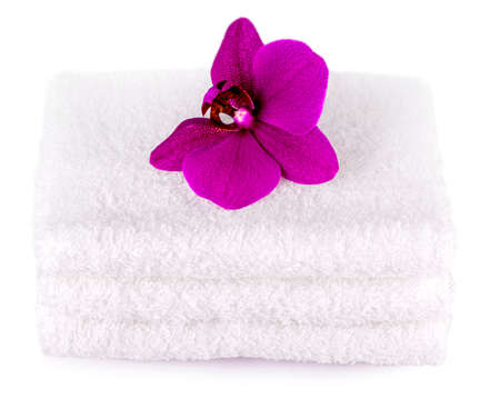 Stack white spa towels on white background  with purple  orchid flowerの写真素材