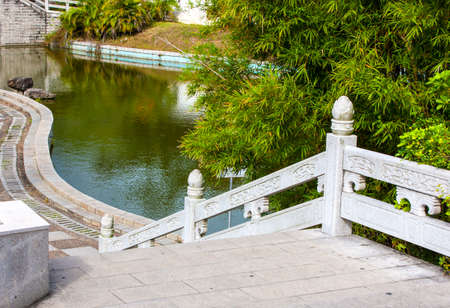 stone staircase with railing and walkway along the pondの写真素材