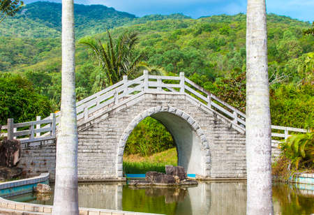 The bridge across the pond in Chinese Gardenの写真素材