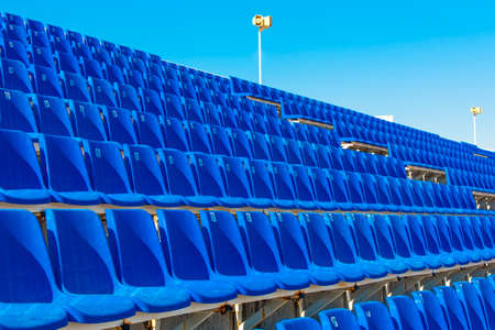 Rows of empty blue color plastic stadium seating on the terrace.の写真素材