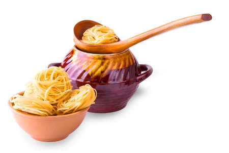 italian pasta fettuccine nests in in a clay Cup on whiteの写真素材