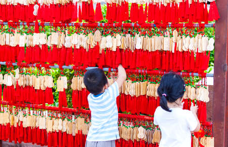 China, Sanya - 15 Nov 2017: Chinese children hang EMA in a Buddhist templeのeditorial素材