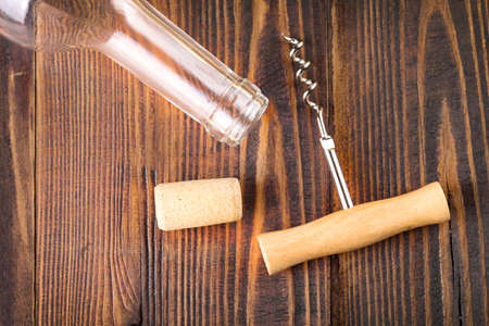 EMPTY BOTTLE, CORKSCREW AND stopper on wooden surfaceの写真素材
