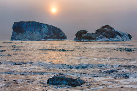 the harsh winter landscape morning ocean rocks の写真素材