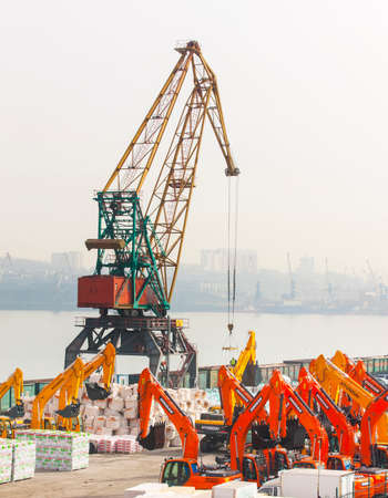 Vladivostok, Russia- March, 28, 2018: Tractors waiting loading  and cranes in seaport of Vladivostokのeditorial素材