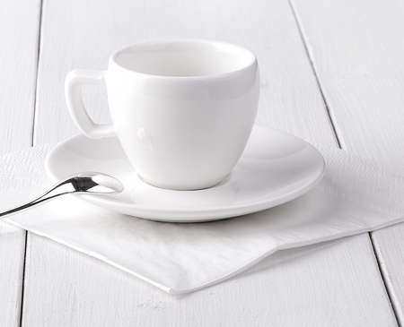 The white empty cup of coffee on a white napkin