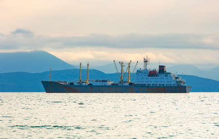 The fishing boat in gray morning on Pacific ocean off the coast of the Kamchatka Peninsulaの写真素材