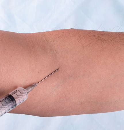 the vaccine injection in hand of man