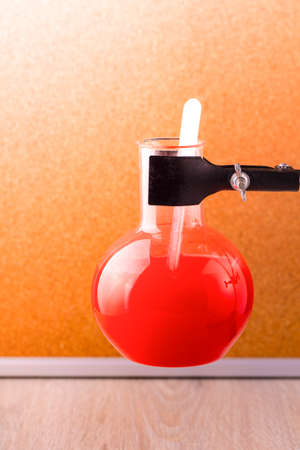 Test flask with red liquid in the wooden backgroundの写真素材