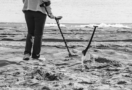 The Finding coins in the sand on the beach with a metal detector