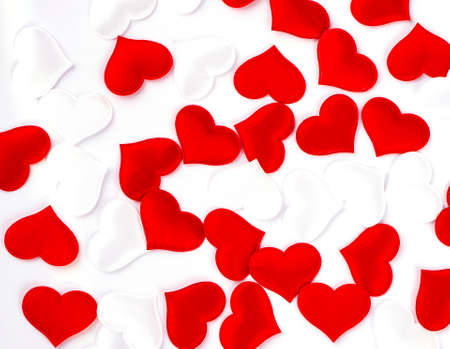Red and white hearts on white textured fabric background