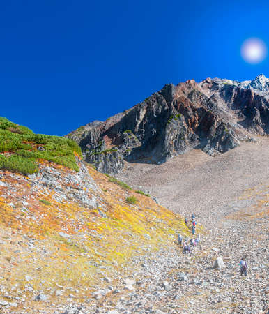 The Hiking group of people on tourist track climb to steep slope crater of volcanoの写真素材