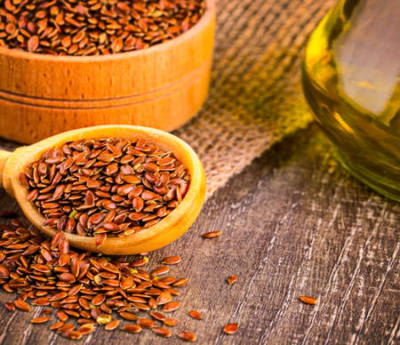 The Brown flax seeds and flaxseed oil on a wooden tableの写真素材
