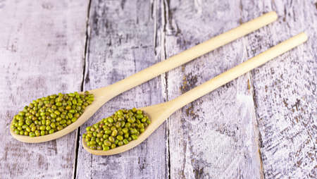 The Mung beans in a spoon on a old wooden table