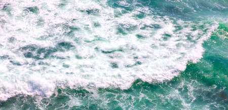 The scenic aerial shot of blue ocean with foamy waves for backgroundの写真素材