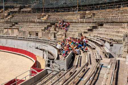 Arles, France - JUNE 19 - 2018: A group of tourists resting on the steps of the ancient amphitheater.のeditorial素材