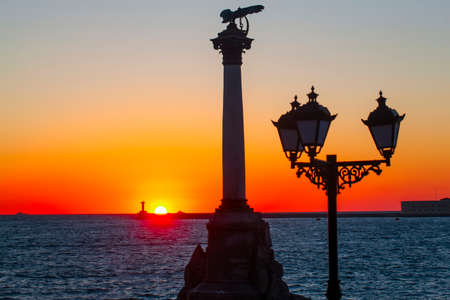 The sunset on the embankment of Sevastopol. The symbol of Sevastopol is a Monument to sunken ships, a historical memorial.の写真素材