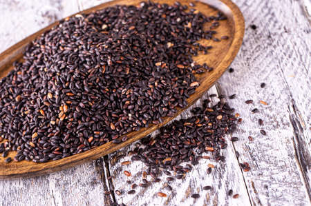 The black rice on old wooden tableの写真素材