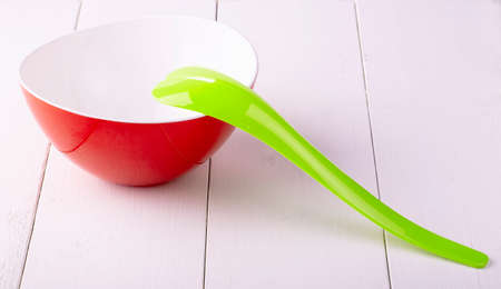 green plastic spoon salad on white wooden tableの写真素材