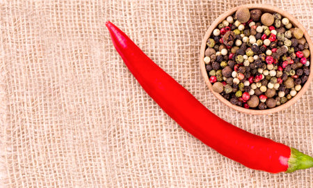 Red hot chili pepper on wooden bagging backround with wooden cup and colore peppersの写真素材