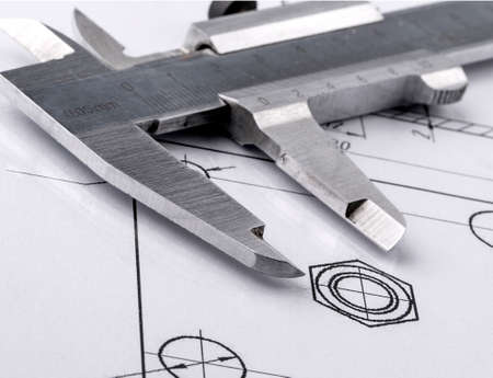 Old metal caliper and engineering drawing.